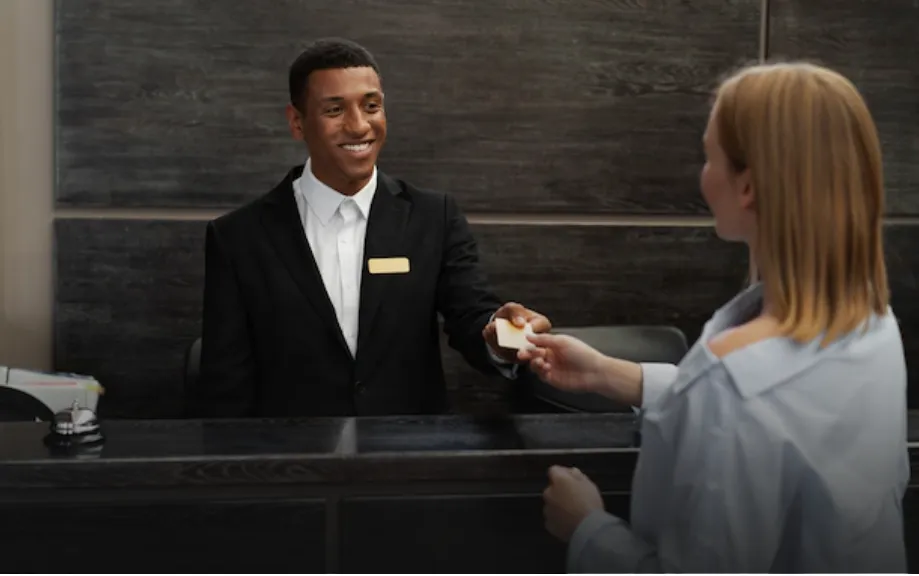 Un hôtelier qui donne son badge d'accès à une cliente