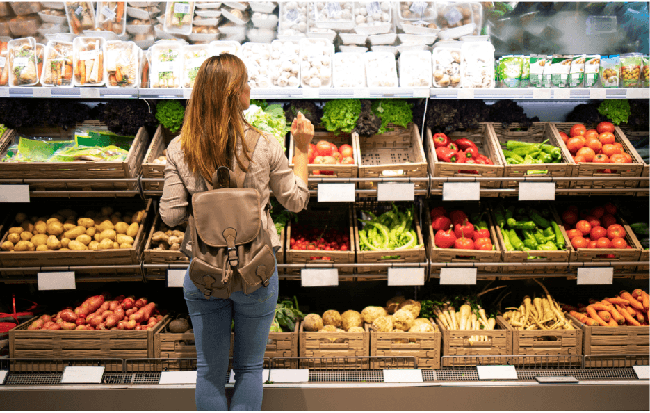 Femme en train de choisir des légumes dans un rayon